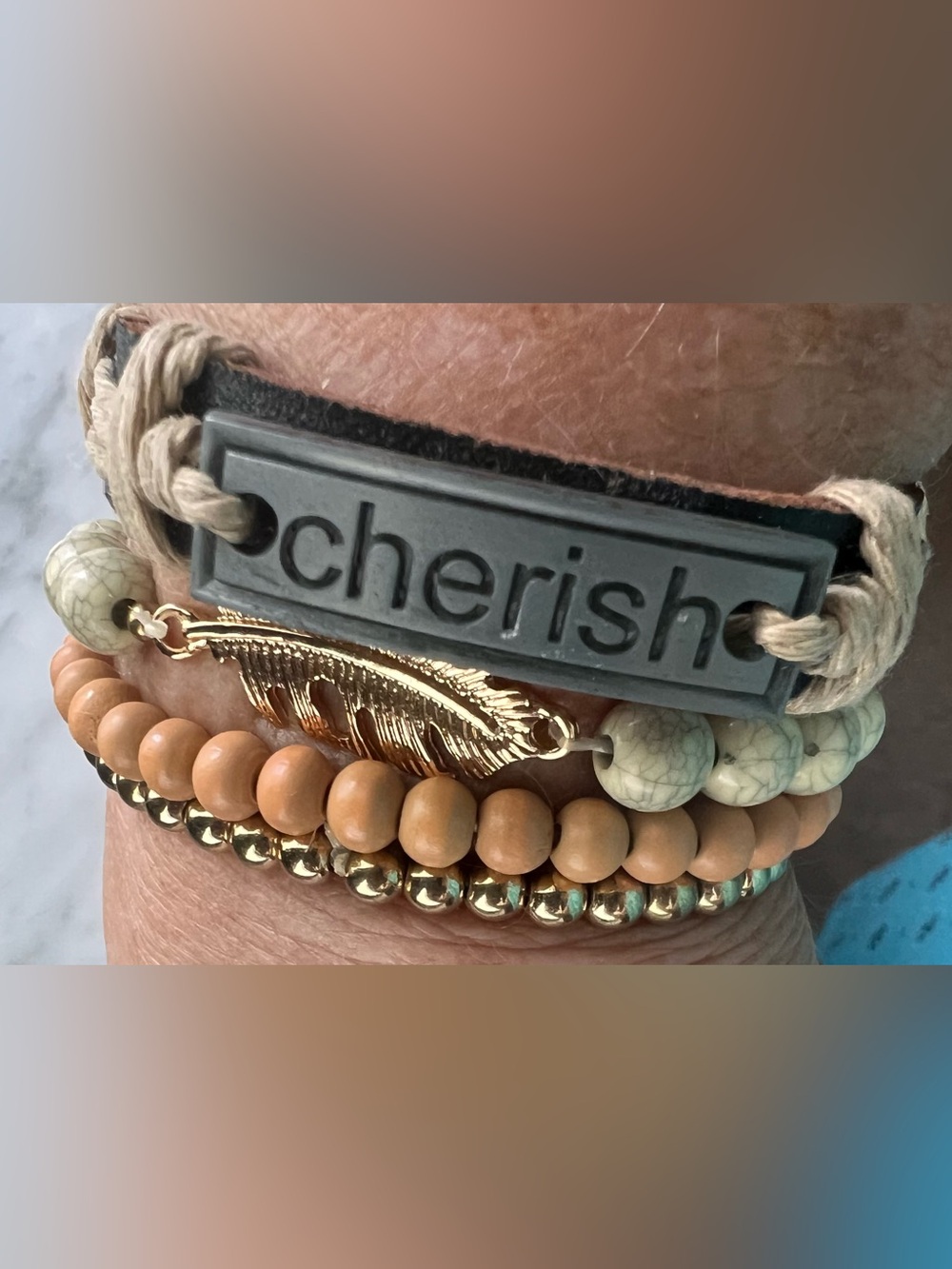 Beaded “Cherish” and Charm Bracelet Set of 4 in Gold with neutral colors.